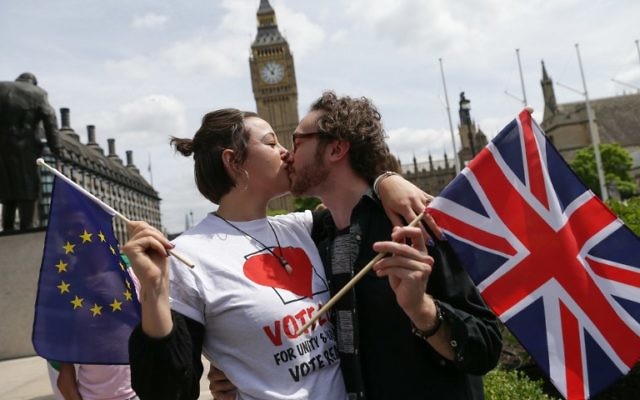 La campagne du "Remain", pour que le Royaume-Uni reste dans l'Union européenne, avait organisé une chaîne de baisers entre des personnes portant des drapeaux du Royaume-Uni et de l'Union européenne, devant la Chambre du Parlement, à Londres, le 19 juin 2016. (Crédit : AFP/Daniel Leal-Olivas)