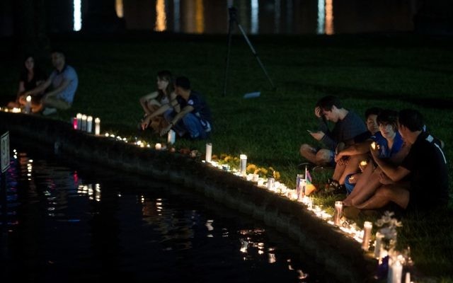Hommage aux victimes de la fusillade terroriste d'Orlando au bord du lac Eola, à Orlando, le 12 juin 2016. (Crédit : Drew Angerer/Getty Images/AFP)