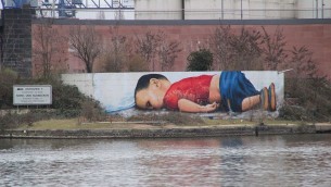 La fresque réalisée par deux artistes allemands et représentant Aylan Kurdi, enfant de trois ans mort noyé en Méditerranée. (Crédits : Frank C. Müller / Wiki Commons)