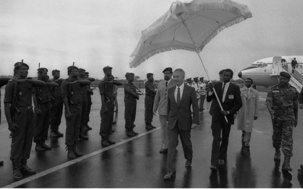 Le Premier ministre Shimon Peres passe en revue une garde d'honneur à Douala, au Cameroun, avant de rentrer en Israël, le 26 août 1986. (Crédit : Nati Harnik/GPO)