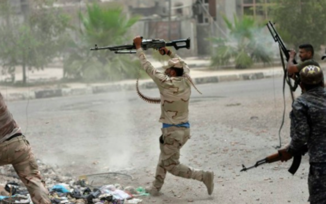 Les forces gouvernementales irakiennes se heurtent aux combattants du groupe de l'Etat islamique (IS) à Falloujah le 18 juin 2016 (Crédit : Stringer / AFP)