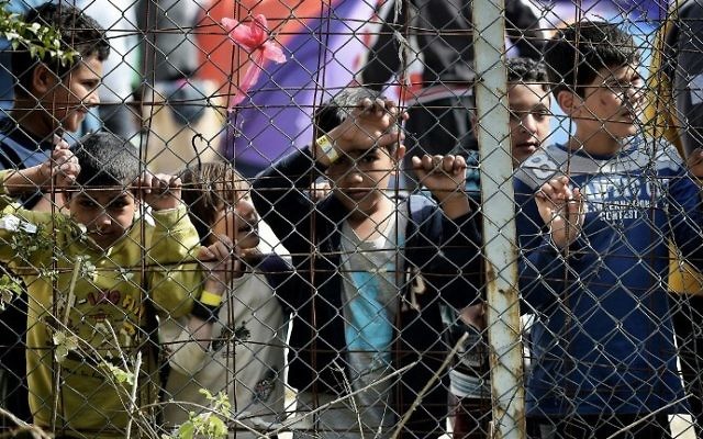 Photo d'illustration : Des enfants derrière une clôture, dans le camp pour migrants de Moria, transformé par la police en centre de détention, à Mytilene, sur l'île de Lesbos, en Grèce, le 3 avril 2016. (Crédit : Aris Messinis/AFP)