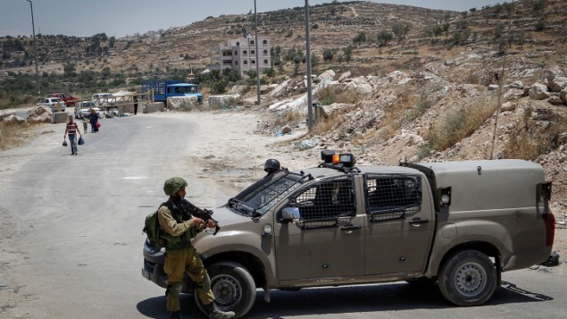 Soldats israéliens à un checkpoint à l'entrée du village palestinien de Yatta, en Cisjordanie, le 9 juin 2016. (Crédit : Wisam Hashlamoun/Flash90)