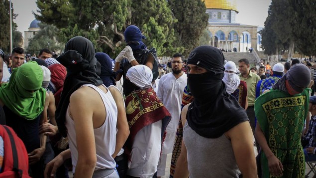 Des Palestiniens masqués avec des pierres pendant des affrontements avec la police sur le mont du Temple, dans la Vieille Ville de Jérusalem, le 28 juin 2016. (Crédit : Muammar Awad/Flash90)
