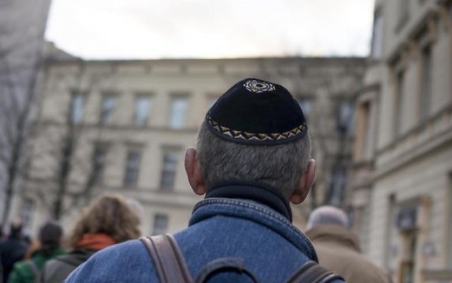 Un homme portant une kippa pendant la marche silencieuse commémorant le 75e anniversaire des pogroms de la Nuit de Cristal, ou Kristallnacht, à Berlin, le 9 novembre 2013. (Crédit : Carsten Koall/Getty Images via JTA)
