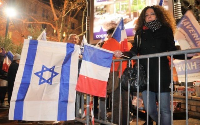 Des juifs français agitant des drapeaux israéliens et français devant l'Hyper Cacher un an après que quatre clients juifs aient été assassinés lors d'un attentat terroriste dans le magasin casher Paris, 9 janvier 2016. (Crédit photo: Serge Attal / Flash90)