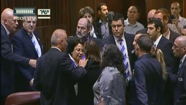 Altercation entre la députée Hanin Zoabi de la Liste arabe unie, au centre, et d'autres élus en séance plénière de la Knesset après son discours sur l'accord de réconciliation entre Israël et la Turquie, le 29 juin 2016. (Crédit : capture d'écran Chaîne de la Knesset)