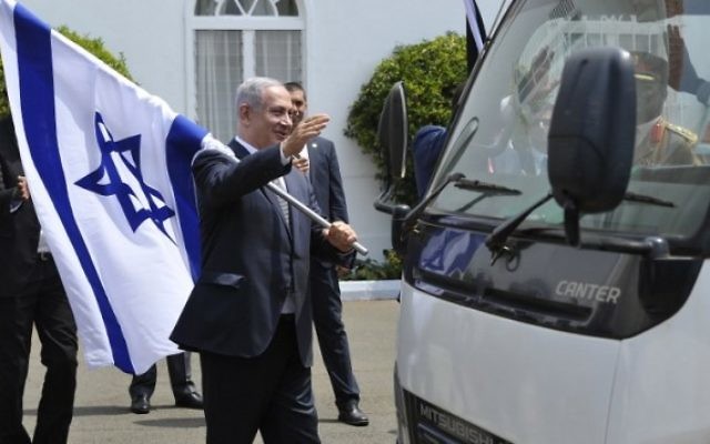 Le Premier ministre Benjamin Netanyahu avec un drapeau israélien après une conférence de presse commune avec le président du Kenya, à Nairobi, le 5 juillet 2016. (Crédit : AFP/Simon Maina)