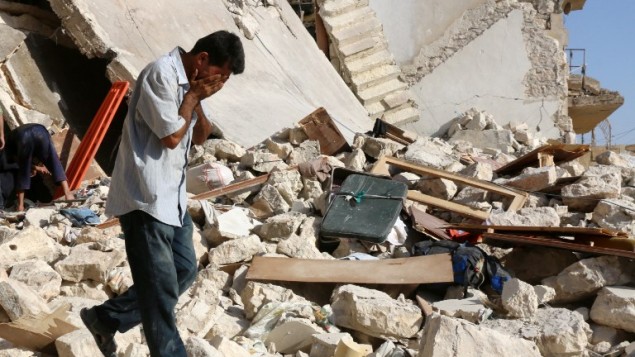 Un Syrien réagit alors que les secouristes recherchent des victimes sous les décombres d'un bâtiment effondré suite à une frappe aérienne sur le quartier rebelle de Sakhur dans la ville du nord, Alep, le 19 juillet, 2016 (Crédit : AFP / Thaer Mohammed)