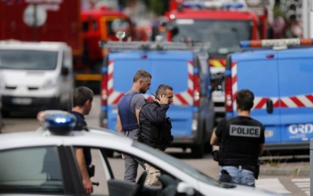 Des policiers et des pompiers français sur les lieux d'une prise d'otages dans une église de Saint-Etienne-du-Rouvray, dans le nord ouest de la France, le 26 juillet 2016. (Crédit : Charly Triballeau/AFP)