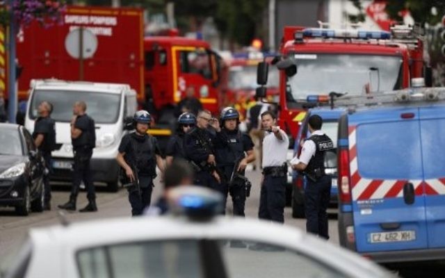 Des policiers et des pompiers français sur les lieux d'une prise d'otages dans une église de Saint-Etienne-du-Rouvray, dans le nord ouest de la France, le 26 juillet 2016. (Crédit : Charly Triballeau/AFP)