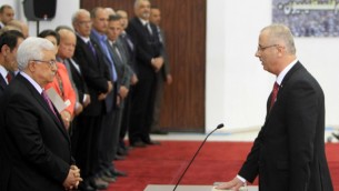Le Premier ministre de l'Autorité palestinienne (AP) Rami Hamdallah (à droite) prête serment avec le nouveau gouvernement d'unité palestinien, en présence du président de l'AP Mahmoud Abbas (à gauche), à Ramallah, en Cisjordanie, le 2 juin 2014. (Crédit : AFP/Abbas Momani)