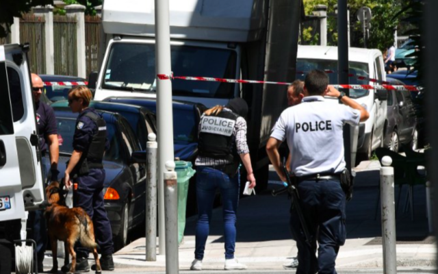 Des policiers et gendarmes français se tiennent à côté d'un camion dans une rue de Nice le 15 Juillet 2016, à proximité du domicile où le terroriste aurait vécu. (Crédit : AFP/Anne-Christine Poujoulat)