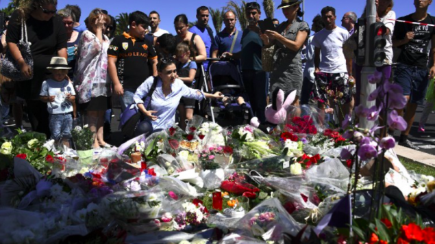 Les gens déposent des fleurs dans les rues de Nice pour rendre hommage aux victimes le lendemain de l'attaque, le 15 juillet 2016. (Crédit : AFP/Anne-Christine Poujoulat)