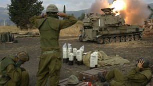 Les soldats israéliens couvrent leurs oreilles alors qu'ils tirent des obus d'artillerie dans le sud du Liban depuis l'extérieur de Kiryat Shmona, dans le nord d'Israël au cours de la seconde guerre du Liban, le 22 juillet, 2006. (Crédit : Pierre Terdjman / Flash90)