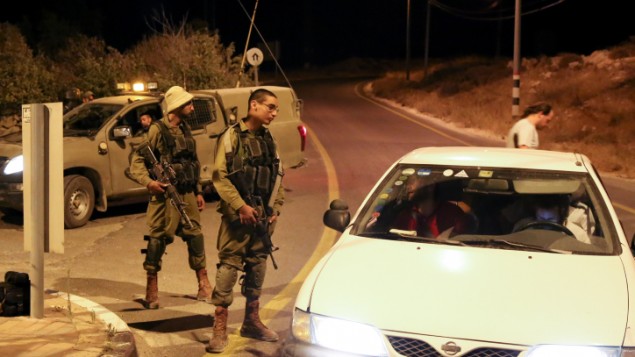Des soldats israéliens bloquent la sortie de l'implantation juive d'Efrat, dans le Gush Etzion, suite à une attaque à main armée dans les environs, le 9 juillet 2016. (Crédit : Gershon Elinson/Flash90)