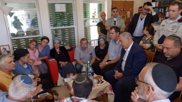 Le Premier ministre Benjamin Netanyahu (assis, deuxième à droite) et le ministre de la Défense Avigdor Liberman (assis, à droite) se sont joints à la famille et aux proches chez Hallel Yaffa Ariel à Kiryat Arba, le 1er juillet 2016, un jour après qu'elle a été poignardée à mort dans son lit. (Crédit : Amos Ben Gershom/GPO)