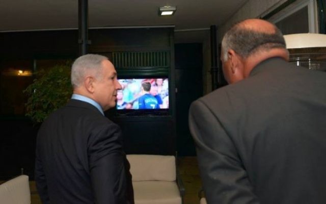 Le Premier ministre Benjamin Netanyahu et son invité, le ministre égyptien des Affaires étrangères Sameh Choukri, regardent la finale de l'Euro de football 2016 entre la France et le Portugal dans la résidence du Premier ministre à Jérusalem, le 10 juillet 2016. (Crédit : Haim Zach/GPO)