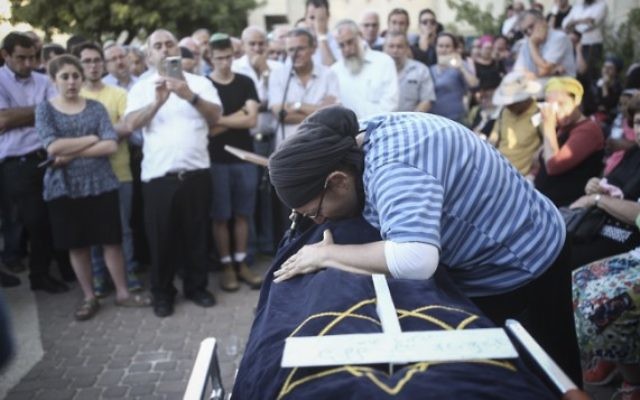 Rina  Ariel pleure sur la dépouille de sa fille de 13 ans, Hallel Yaffa, qui a été poignardée à mort par un terroriste palestinien dans sa chambre, pendant son éloge funèbre, dans l'implantation de Kiryat Arba, le 30 juin 2016. (Crédit : Yonatan Sindel/Flash90)