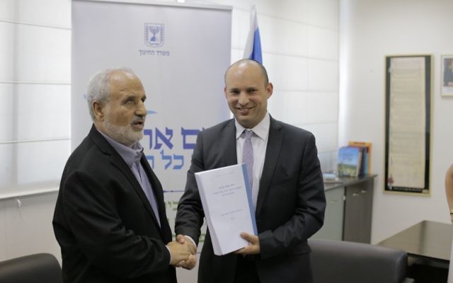 Le ministre de l'Education Naftali Bennett (à droite) sert la main du prix d'Israël Erez Biton après avoir reçu les recommandations du comité pour augmenter l'éducation sur les Mizrahi dans les écoles israéliennes, le 7 juillet 2016 (Crédit : ministère de l'Education)