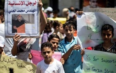 Manifestation de soutien à Mohammed Halabi, directeur pour Gaza de World Vision, à Gaza Ville, le 7 août 2016. (Crédit : Mahmud Hams/AFP)