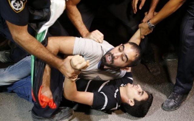 La police israélienne arrête des manifestants qui protestent contre la détention administrative du prisonnier palestinien Bilal Kayed, qui est en grève de la faim depuis 56 jours, devant l'hôpital d'Ashkelon où il est détenu, le 9 août 2016. (Crédit : AFP/Ahmad Gharabli)