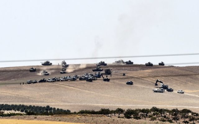 Les tanks turcs et les combattants de l'opposition syrienne pro-Ankara à deux kilomètres à l'ouest de la ville syrienne de Jarablos, à Karkamis, une ville turque frontalière, le 24 août 2016. (Crédit : AFP/Bulent Kilic)