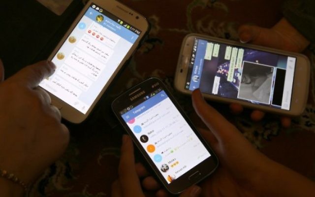 Des Iraniens utilisent l'application Telegram sur leurs téléphones, le 1er décembre 2015. (Crédit : AFP/Atta Kenare)
