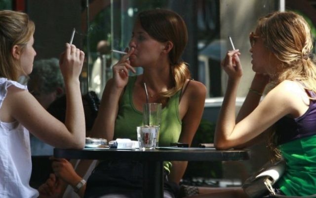 De jeunes Israéliennes fument des cigarettes dans un café du centre de Tel Aviv. (Crédit : Kobi Gideon/Flash90)