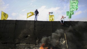 Drapeaux du Fatah, du Hamas et d'autres mouvements palestiniens au sommet de la barrière de sécurité de Cisjordanie, pendant une manifestation en novembre 2015. Illustration. (Crédit : Muammar Awad/Flash90)