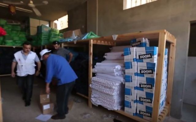 Une distribution de l'aide Save the Children distribution dans un entrepôt dans la bande de Gaza, en 2014 (Crédit : Save the Children / YouTube)