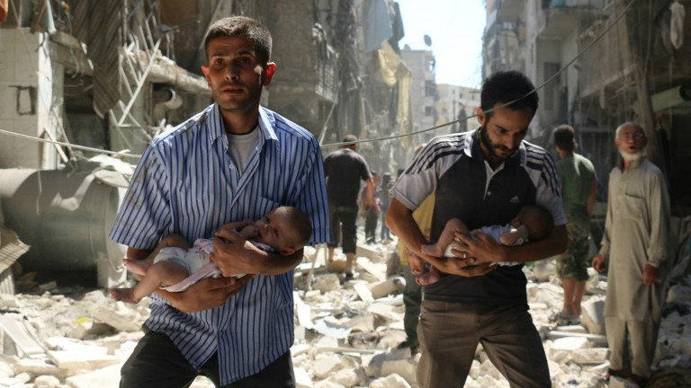 Des Syriens avec des bébés traversent les ruines de bâtiments détruits après une frappe aérienne sur le quartier tenu par les rebelles de Salihin, à Alep, le 11 septembre 2016. (Crédit : AFP/Ameer Alhalbi)
