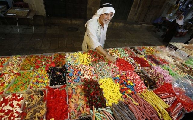 Un Palestinien achète des bonbons pendant la préparation des magasins musulmans à la fête de l'Aïd al-Adha, sur le marché de la Vieille Ville de Jérusalem, le 11 septembre 2016. (Crédit : AFP/Hazem Bader)