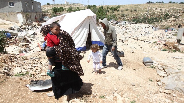 Une famille palestinienne dont la maison a été démolie par Israël à Ad-Deirat Rifaiyya, dans le sud de la Cisjordanie, le 21 avril 2015. (Crédit : Hazem Bader/AFP)