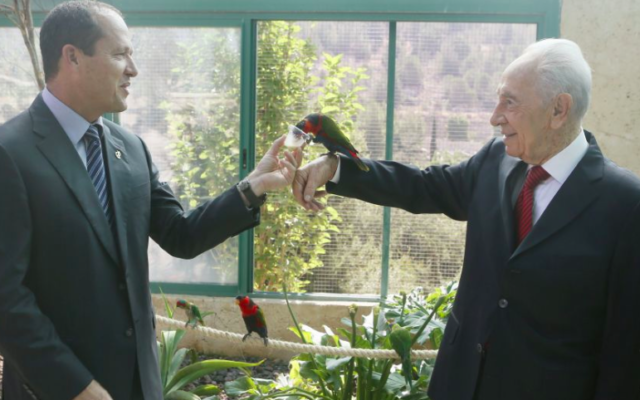 Shimon Peres, alors président, et le maire de Jérusalem, Nir Barkat (à gauche) avec des perroquets au Zoo biblique de la capitale, le 2 juillet 2013. (Crédit : Miriam Alster/Flash90)