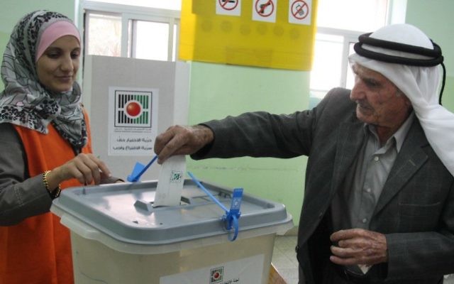 Un Palestinien glisse son bulletin de vote dans l'urne lors des élections municipales dans la ville d'Al-Bireh, en Cisjordanie, le 20 octobre 2012. (Crédit : Issam Rimawi/Flash90)