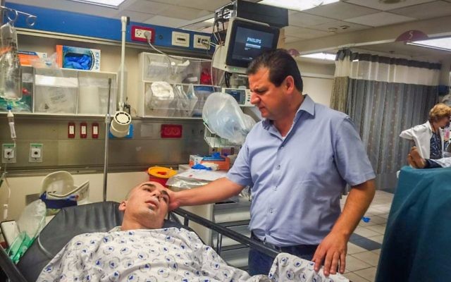 Ayman Odeh, député de la Liste arabe unie, rend visite à une des victimes de l'effondrement d'un immeuble en construction à Tel Aviv à l'hôpital Ichilov, le 5 septembre 2016. La victime a donné son accord pour être photographiée. (Crédit : porte-parole de la Liste arabe unie)