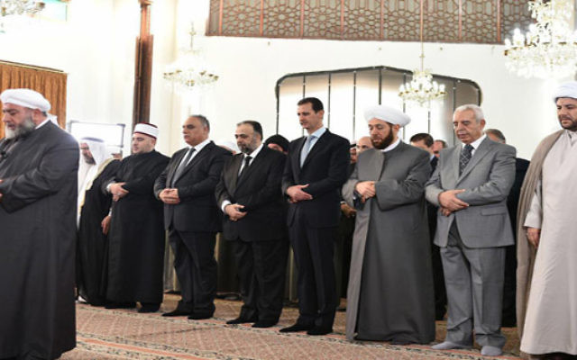 Le président syrien Bashar el-Assad (4° à droite) pendant les prières de l'Aïd al-Fitr à Homs, le 6 juillet 2016. (Crédit : SANA)