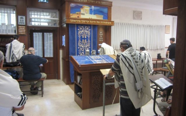 Un homme prie dans une synagogue. Illustration. (Crédit : Ben Sales/JTA)