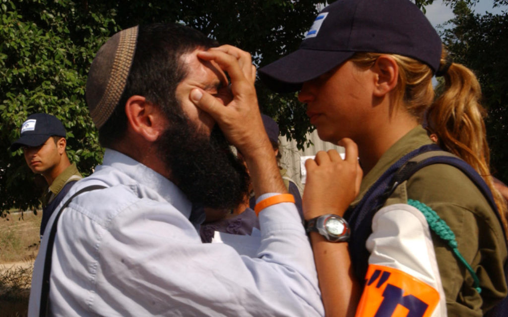 Un résident juif d'une implantation argumente avec une soldate pendant le désengagement de la bande de Gaza, le 17 août 2005. (Crédit : Yossi Zamir/Flash90)