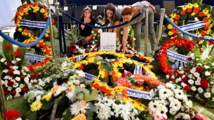 Des Israéliennes sur la tombe de l'ancien président Shimon Peres, après son enterrement au cimetière national du mont Herzl, à Jérusalem, le 30 septembre 2016. (Crédit : AFP/Gil Cohen-Magen)