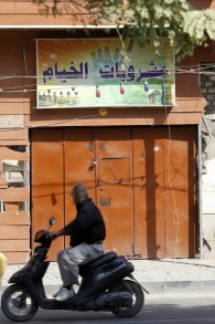 Un Irakien passe devant un magasin d'alcool fermé à Bagdad, le 23 octobre 2016. (Crédit : AFP/Sabah Arar)