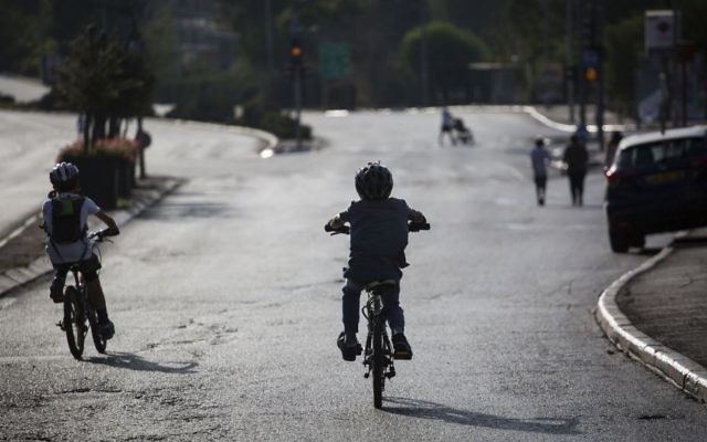 Des enfants font du vélo dans les rues vides de voiture de Jérusalem pendant Yom Kippour, le 12 octobre 2016. (Crédit : Hadas Parush/Flash 90)
