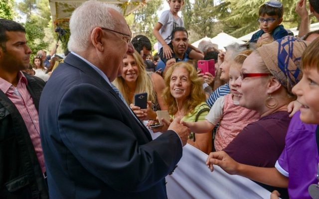 Le président israélien Reuben Rivlin accueille les visiteurs lors de la "Soucca ouverte" à Jérusalem, le 19 octobre 2016. (Crédits : Roy Berkovich / GPO)