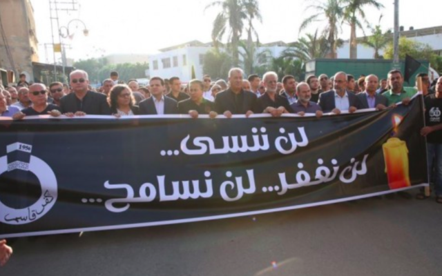 Des membre de la Liste Arabe Unie se rassemblent à Kafr Kassem pour commémorer le soixantième anniversaire du massacre commis par la Police des Frontières israélienne dans le village. Sur la bannière, on peut lire : "Nous n'oublierons pas ni ne pardonnerons" (Crédit : Porte-parole de la Liste Arabe Unie)