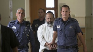 Alon Shamir, thérapeute de 50 ans accusé d'avoir violé deux de ses patients, est escorté par les gardiens de prison à son arrivée à une audience du tribunal à Jérusalem, le 7 août 2016. (Crédit : Yonatan Sindel/Flash90)