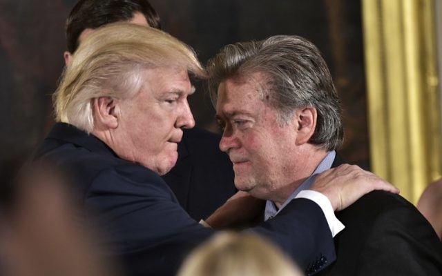 Le président américain Donald Trump, à gauche,  félicite son conseiller Stephen Bannon après l'investiture des hauts responsables dans la salle est de la Maison Blanche, le 22 janvier 2017. (Crédit : Mandel Ngan/AFP)