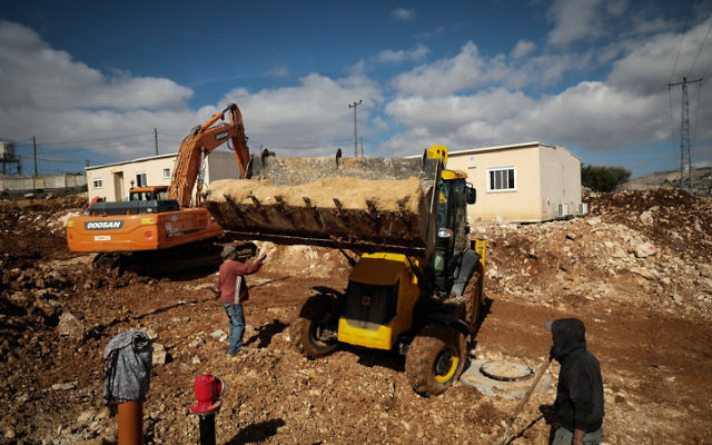 Les employés en bâtiment défrichant des terrains pour de nouvelles caravanes dans l'implantation juive d'Ofra, en Cisjordanie, le 29 janvier 2017. (Crédit : Yaniv Nadav/Flash90)