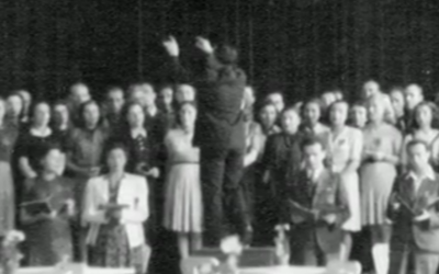 Seule photographie connue des détenus de Theresienstadt chantant le Requiem de Verdi, prise pendant la dernière représentation le 23 juin 1944. Raphael 'Rafi' Schachter dirige la chorale, devant un public où était présent Adolf Eichmann et une délégation de la Croix Rouge internationale. (Crédit : Fondation Terezin)