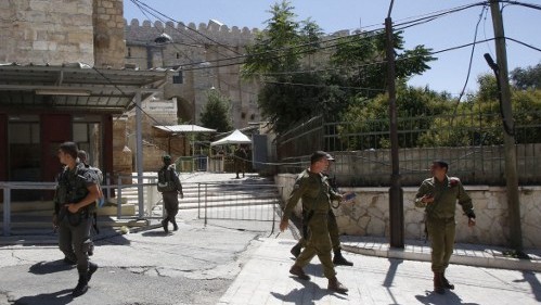 Forces de sécurité devant l'entrée du Tombeau des Patriarches, à Hébron, en Cisjordanie, le 1er juillet 2016. (Crédit : Hazem Bader/AFP)